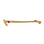 AN ANTIQUE RUBY CROP BROOCH in 14ct yellow gold, designed as a riding crop set with a round cut r...