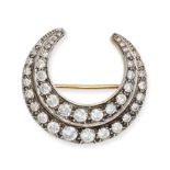 A DIAMOND CRESCENT MOON BROOCH in yellow gold and silver, designed as a crescent moon set with tw...