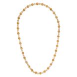 A COIN CHAIN NECKLACE in yellow gold, comprising a series of links set with small coins, each coi...