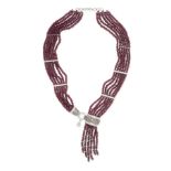 A RUBY AND DIAMOND TASSEL NECKLACE in 18ct white gold, comprising six rows of faceted ruby beads ...