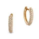 A PAIR OF DIAMOND HUGGIE HOOP EARRINGS in 18ct yellow gold, each hoop set with three rows of roun...