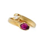 A RUBY AND DIAMOND RING in 18ct yellow gold, in crossover design, set with an oval cut ruby and r...