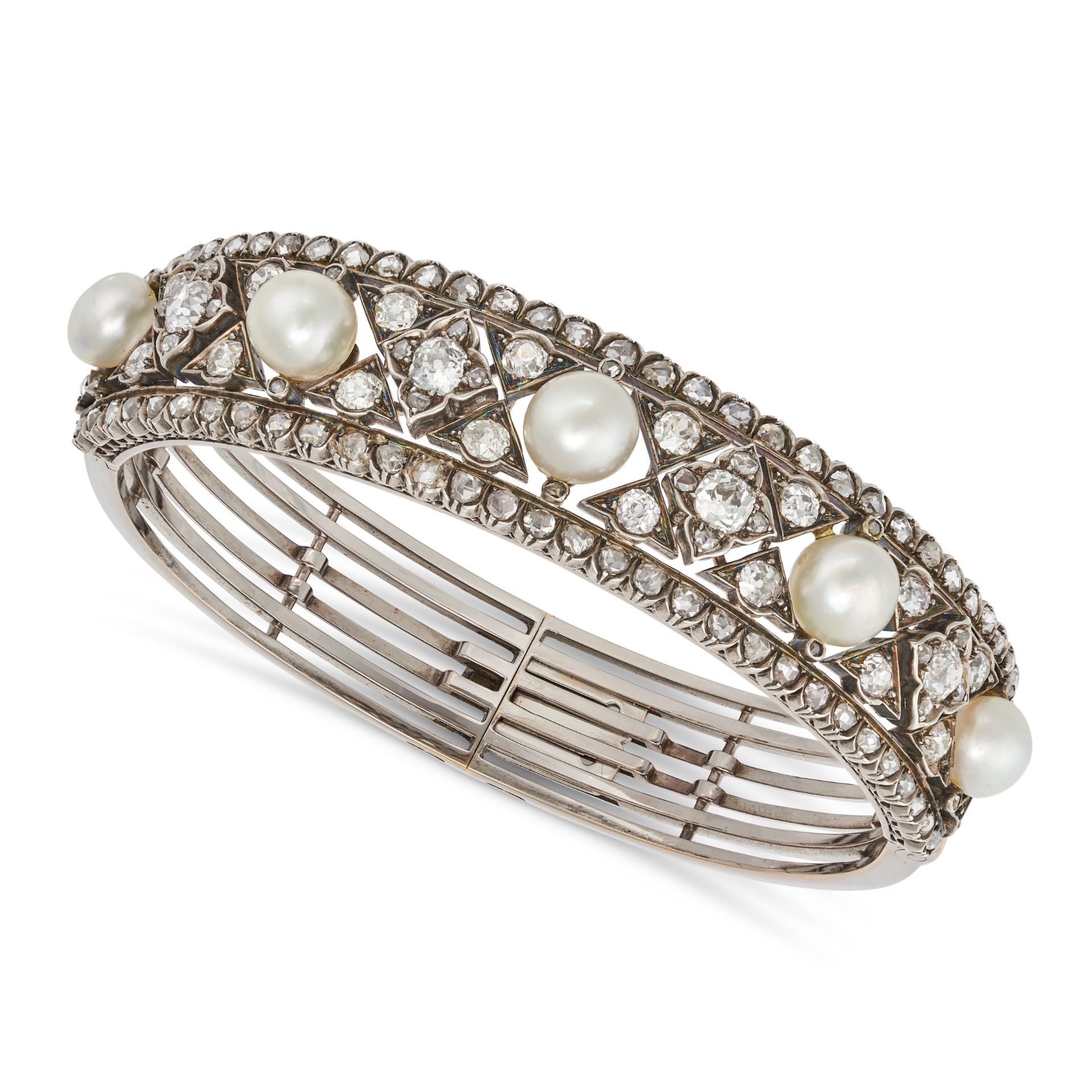 AN ANTIQUE PEARL AND DIAMOND BANGLE set with a row of alternating pearls and quatrefoil motifs se...