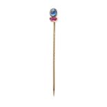 A SAPPHIRE AND RUBY STICK / TIE PIN in yellow gold, set with an oval cabochon sapphire and a half...