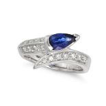 A SAPPHIRE AND DIAMOND CROSSOVER RING in platinum, set with a pear cut sapphire accented by round...