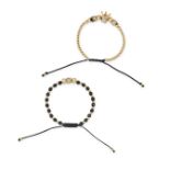 A PAIR OF BRACELETS one strung with black and gold beads and accented by a cubic zirconia set cub...