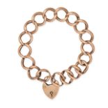 A CURB LINK PADLOCK BRACELET in 9ct yellow gold, comprising a series of links with a heart shaped...