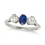 A SAPPHIRE AND DIAMOND THREE STONE RING in platinum, set with an oval cut sapphire between two ro...