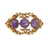 AN ANTIQUE AMETHYST BROOCH in 9ct yellow gold, set with three oval cut amethysts within a stylise...