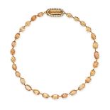 AN ANTIQUE IMPERIAL TOPAZ AND PEARL RIVIERE NECKLACE in 14ct yellow gold, comprising a row of ova...