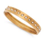 AN ANTIQUE PEARL BANGLE in yellow gold, the hinged bangle set with a row of pearls, no assay mark...
