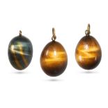 A GROUP OF THREE TIGER'S EYE EGG PENDANTS each set with a polished tiger's eye drop, no assay mar...