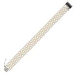 A PEARL, ONYX AND DIAMOND BRACELET designed as a lattice of pearls, the clasp set with a polished...