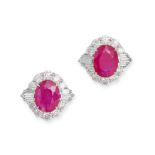 A PAIR OF RUBY AND DIAMOND EARRINGS in 18ct white gold, each set with an oval cut ruby in a clust...