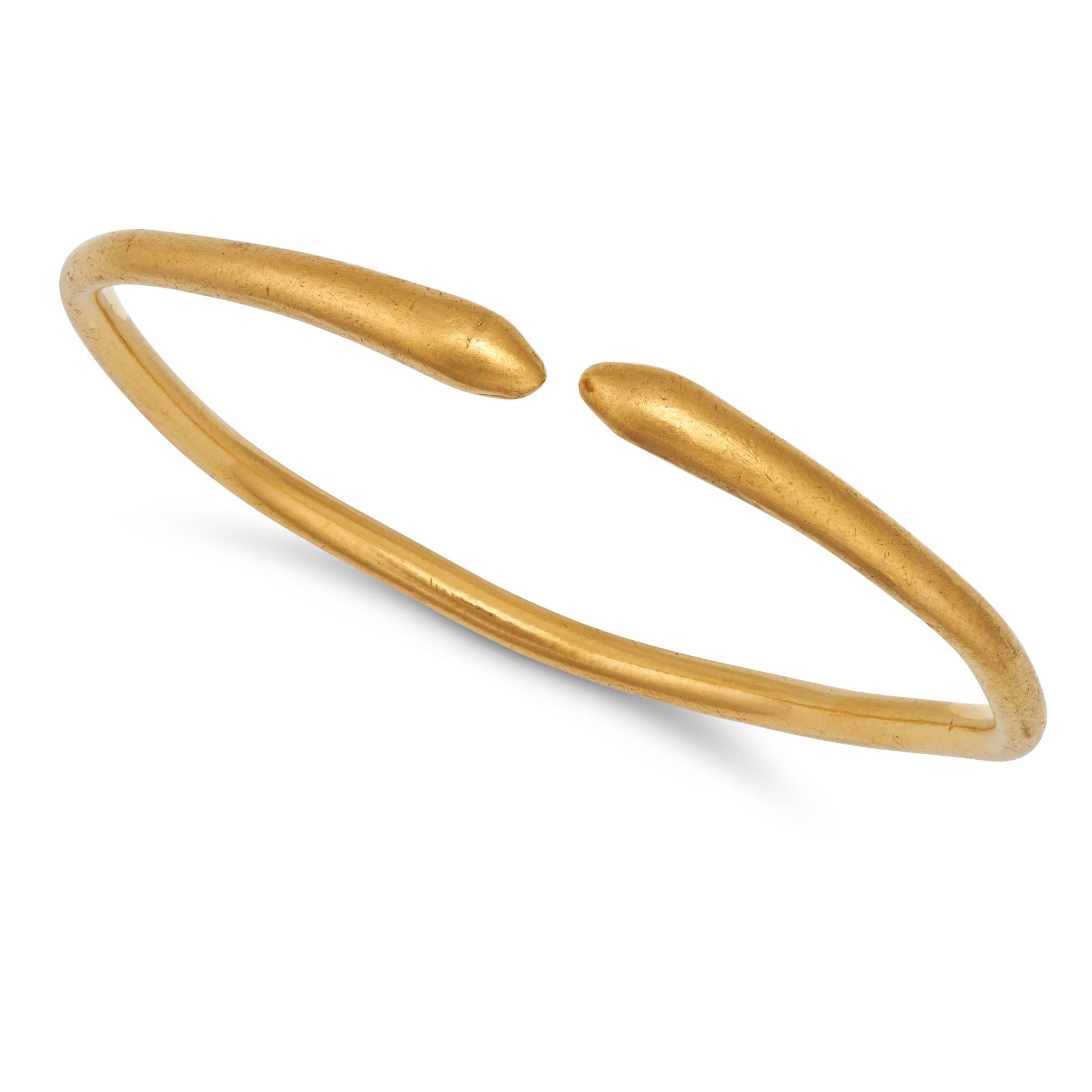 NO RESERVE - A GOLD SNAKE BANGLE in yellow gold, the open cuff bangle terminating at each end wit...