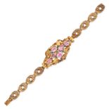 AN ANTIQUE PINK TOPAZ AND EMERALD BRACELET in yellow gold, comprising stylised scrolling links, s...
