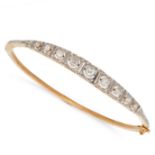 A DIAMOND BANGLE in 18ct yellow gold, the hinged bangle set with a row of graduated old cut diamo...