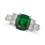 A TSAVORITE GARNET AND DIAMOND RING in platinum, set with a cushion cut tsavorite garnet of appro...