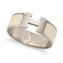 HERMÈS, A CLIC-CLAC H BANGLE, comprising an ‘H’ logo clasp, cream toned enamel, and palladium ton...