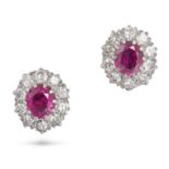 A PAIR OF RUBY AND DIAMOND CLUSTER EARRINGS in yellow gold, each set with an oval cut ruby in a c...