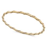 CARTIER, A GOLD BANGLE in 18ct yellow gold, the bangle in a twisted design and accented by rope w...