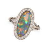 A FINE BLACK OPAL AND DIAMOND RING in white gold, set with a cabochon black opal in a border of s...