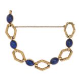 A LAPIS LAZULI BRACELET in 18ct yellow gold, comprising alternating textured openwork links and c...