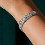 AN ART DECO EMERALD AND DIAMOND BRACELET in platinum, comprising three geometric plaques in folia...