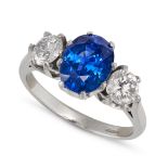 A SAPPHIRE AND DIAMOND THREE STONE RING in platinum, set with an oval cut sapphire of approximate...