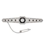 AN ART DECO DIAMOND AND ONYX BAR BROOCH in platinum, set with a principal old cut diamond of 1.18...