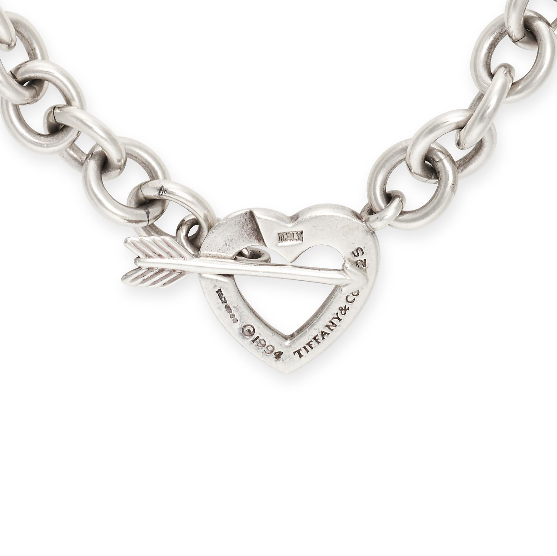 TIFFANY & CO., A SILVER HEART AND ARROW NECKLACE in silver, comprising a trace chain, the clasp d...