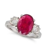 A RUBY AND DIAMOND THREE STONE RING in 18ct white gold, set with an oval cut ruby of 2.41 between...