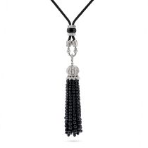 AN ONYX AND DIAMOND TASSEL PENDANT NECKLACE comprising a cord necklace with a polished onyx slide...