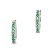 A PAIR OF EMERALD HUGGIE HOOP EARRING in 18ct white gold, each designed as a hoop, set with a row...