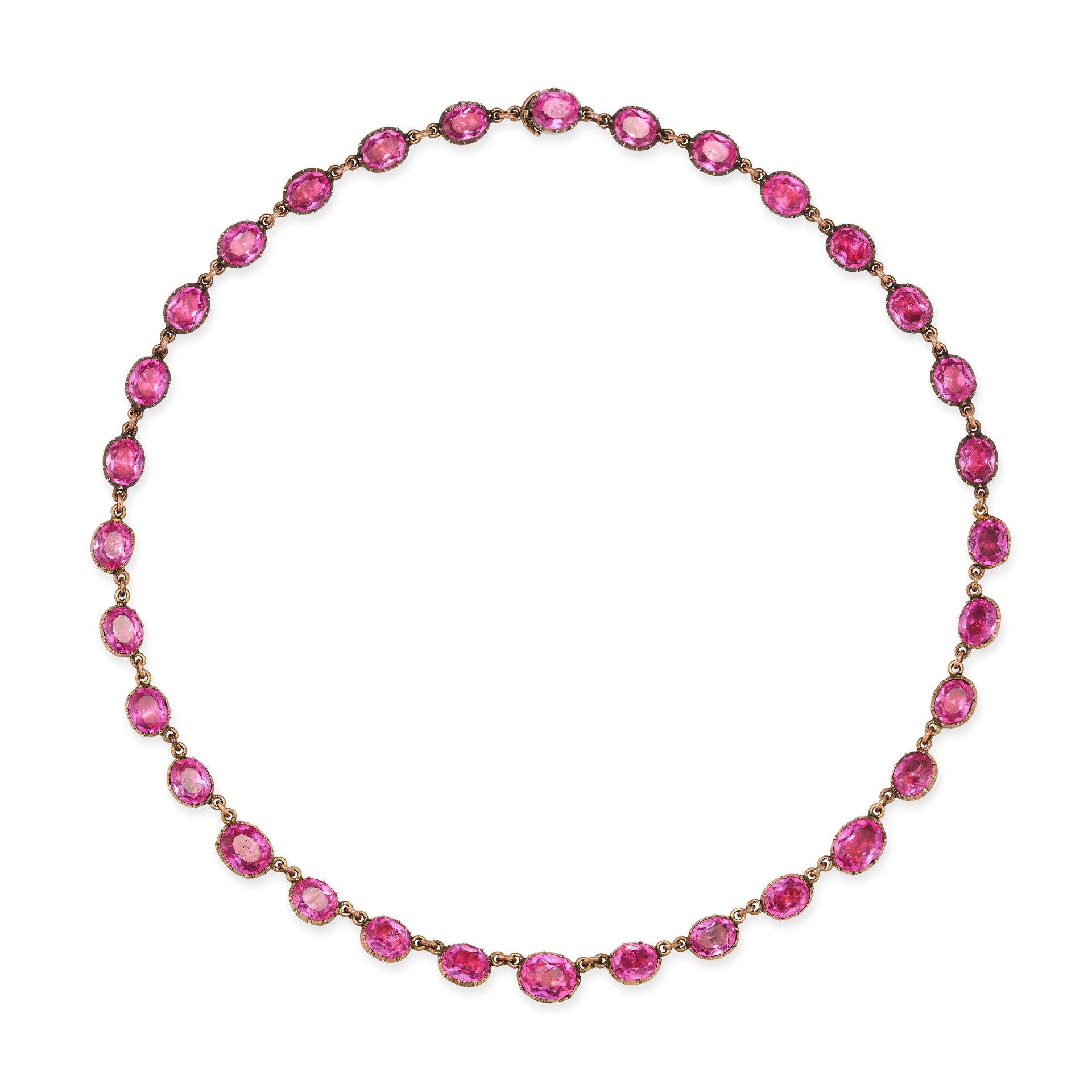 AN ANTIQUE PINK PASTE RIVIERE NECKLACE in yellow gold, comprising a single row of oval cut pink p...