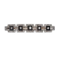 AN ANTIQUE ART DECO ONYX AND DIAMOND BAR BROOCH in yellow gold and silver, the geometric brooch s...