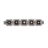 AN ANTIQUE ART DECO ONYX AND DIAMOND BAR BROOCH in yellow gold and silver, the geometric brooch s...