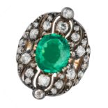 AN ANTIQUE EMERALD AND DIAMOND RING in yellow gold and silver, set with an oval cut emerald of ap...