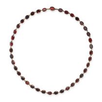 AN ANTIQUE GARNET RIVIERE NECKLACE comprising a row of foil back garnets, no assay marks, 40.5cm,...