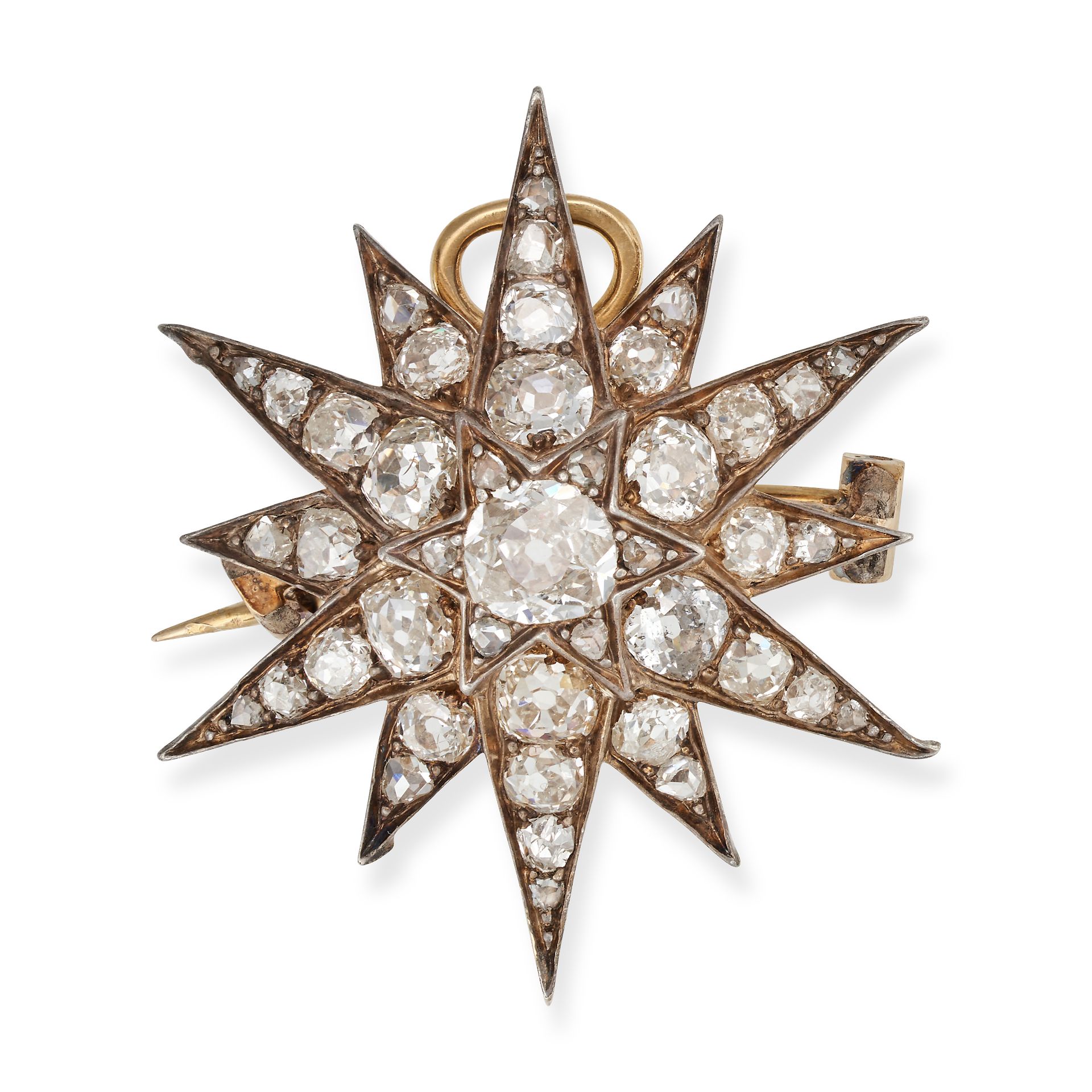 AN ANTIQUE DIAMOND STAR BROOCH / PENDANT in yellow gold and silver, designed as a twelve rayed st...