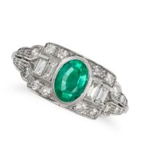 AN EMERALD AND DIAMOND DRESS RING in platinum, set with an oval cut emerald flanked by two baguet...