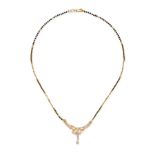 AN ONYX AND WHITE GEMSTONE NECKLACE in 18ct yellow gold, the pendant set with round cut white gem...