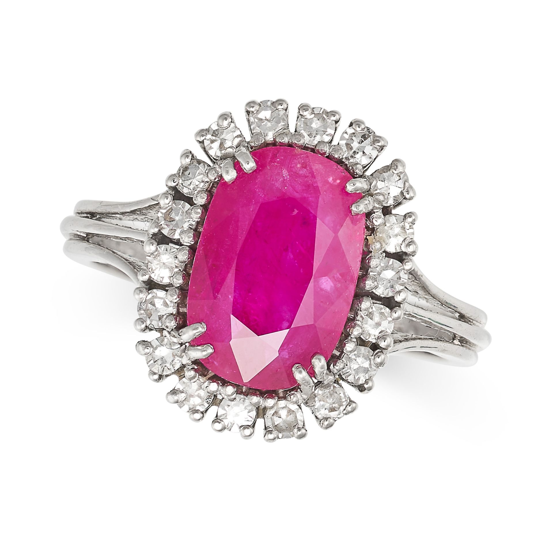 A RUBY AND DIAMOND CLUSTER RING in white gold, set with a cushion cut ruby of approximately 3.38 ...