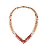VAN CLEEF & ARPELS, A CARNELIAN, MOTHER OF PEARL AND DIAMOND BOUTON D'OR NECKLACE in 18ct rose go...