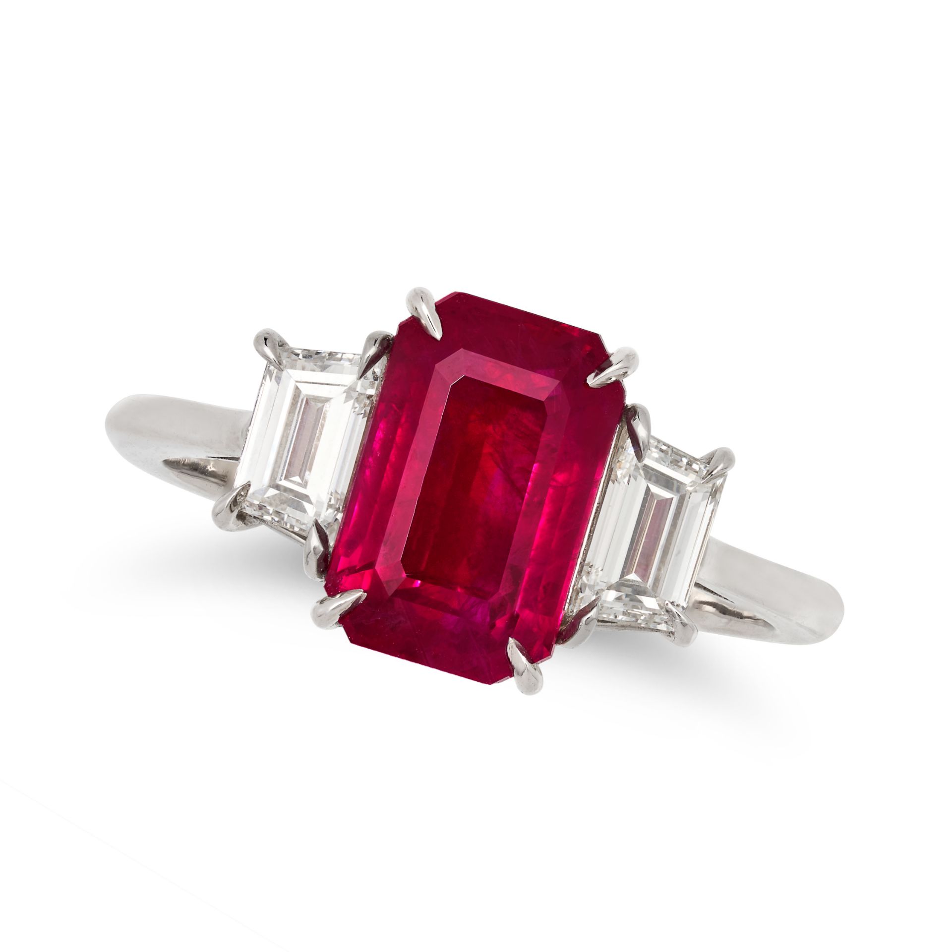 A BURMESE RUBY AND DIAMOND THREE STONE RING in platinum, set with an octagonal step cut ruby of 3...