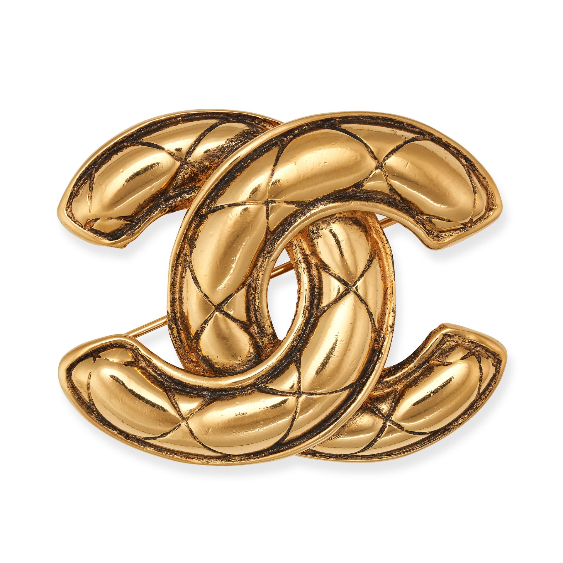 CHANEL, A VINTAGE CC BROOCH plated in 24ct gold, designed as a quilted interlocking 'CC' logo, si...