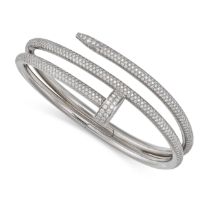 A DIAMOND NAIL BANGLE in 18ct white gold, designed as a curved nail pave set with round brilliant...