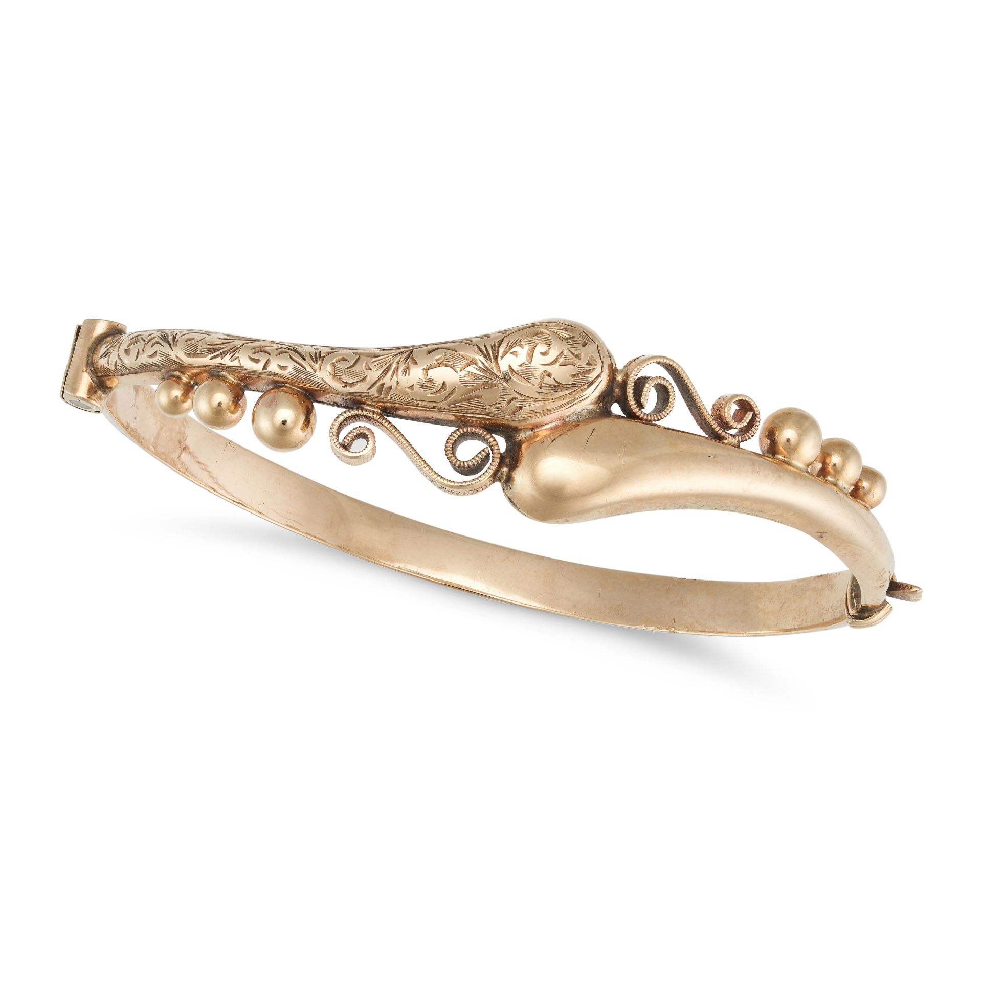 A GOLD BANGLE in 9ct yellow gold, the bangle in a stylised twisted design accented by gold beads,...