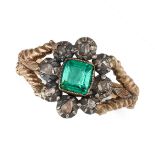 AN ANTIQUE EMERALD AND DIAMOND RING in yellow gold and silver, set with an octagonal step cut eme...