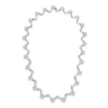 A DIAMOND CLUSTER NECKLACE in platinum, comprising a row of graduating clusters of round brillian...